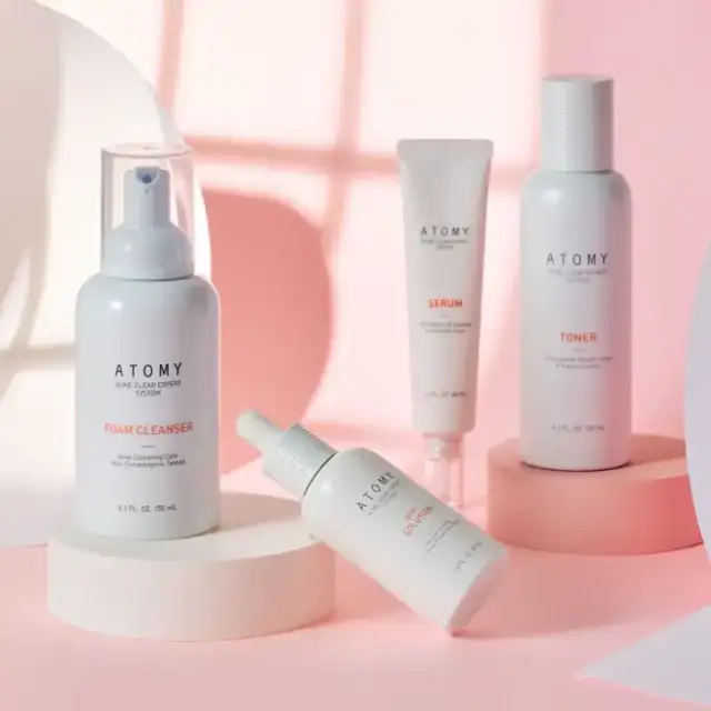 Productos Atomy The Fame sobre fondo rosa