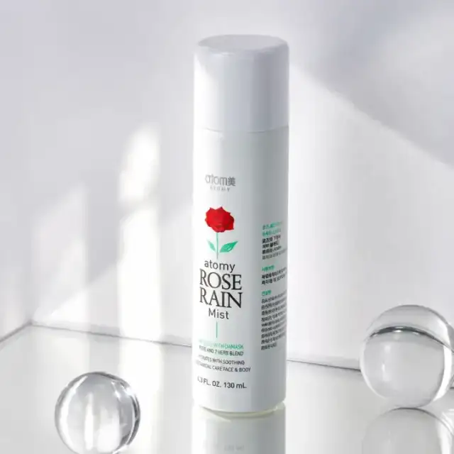 Atomy Rose Rain Mist sobre una superficie luminosa
